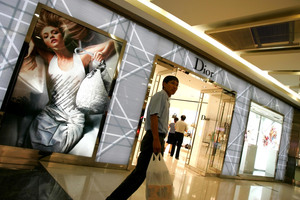 A man walks past a Dior store in Beijing. Photo / AP