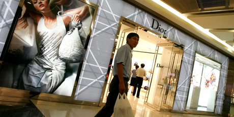 A man walks past a Dior store in Beijing. Photo / AP