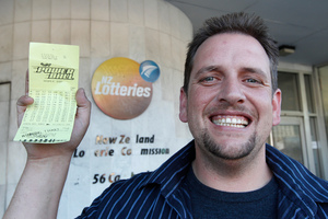 Te Kauwhata supermarket check-out operator Trevor with his winning $26,000,000 Lotto ticket at the NZ Lotteries Commission in Wellington. Photo / Mark Mitchell