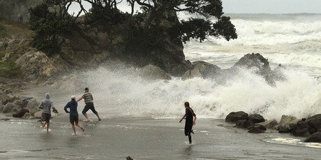 Wild surf whipped the shoreline and spectators were caught out as waves and debris crashed around them on the walkway between the main beach and Leisure Island at Mt Maunganui. Photo / Alan Gibson