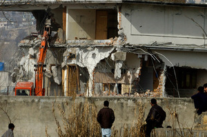Local residents watch as authorities use heavy machinery to demolish the compound of Osama bin Laden in Abbottabad, Pakistan. Photo / AP