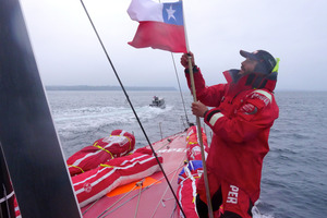 A Chilean flag is hoisted by Roberto Bermudez De Castro presented by the Chilean Navy as Camper approach Porto Montt. Photo / Hamish Hooper.