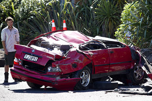 A stolen BMW sits in the car park at Maori Bay in Muriwai after it was pushed of the cliff above on Waitea Road. Photo / Dean Purcell