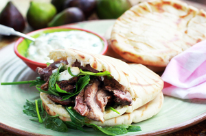 Roasted lamb shoulder with pita and rocket. Photo / Doug Sherring