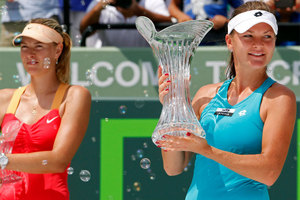 Agnieszka Radwanska. right, of Poland, holds her trophy after defeating Maria Sharapova of Russia, in the women's singles final. Photo / AP.