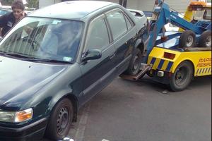 The driver sat in his car after it was hooked to the truck. Photo / Supplied
