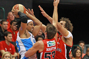 Damian Martin and Matt Knight of the Wildcats defend CJ Bruton of the Breakers. Photo / Getty Images