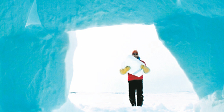 Arctic holiday-maker Robbie Gearing builds an igloo from blocks of ice using techniques shown to him by Inuit guides. Photo / Clare Kendall