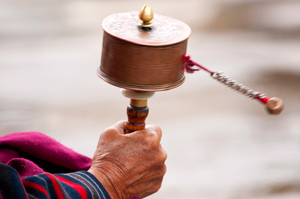 A women spins her prayer wheel in Bhutan, where happiness is valued above almost everything else. Photo / Thinkstock