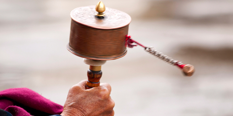 A women spins her prayer wheel in Bhutan, where happiness is valued above almost everything else. Photo / Thinkstock