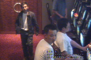 CCTV footage from SkyCity casino's VIP lounge shows Tac Kin Voong (walking) and Ri Tong Zhou (seated wearing glasses). Photo / Supplied