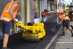 A crew from Downer EDI Works lays hot-mix to give the footpaths in Katikati's Main St. Photo / APN