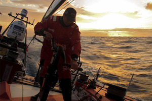 Andy McLean grinding at sunset on the first day, onboard CAMPER with Emirates Team New Zealand during leg 6 of the Volvo Ocean Race. Photo / Hamish Hooper