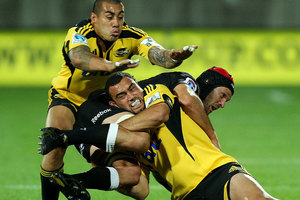 Tusi Pisi (L) and Charlie Ngatai of the Hurricanes tackle Jacques Botes of the Sharks. Photo / Getty Images.