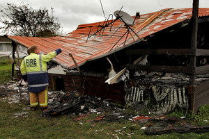 Fire investigators pictured at work on the remains of the house that was destroyed by fire in Rotorua. Photo / APN