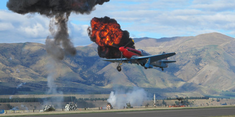 A Russian-made Yak 3 survives a mock anti-aircraft barrage during one of the spectacular displays at Warbirds Over Wanaka. Photo / Michael Walsh