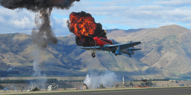 A Russian-made Yak 3 survives a mock anti-aircraft barrage during one of the spectacular displays at Warbirds Over Wanaka. Photo / Michael Walsh