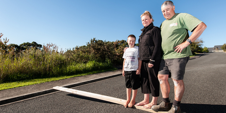Leonie Brittain, husband Chris and son, Jackson, on the road above their land in Paihia the Earthquake Commission says they cannot build on. Photo / Dean Wright