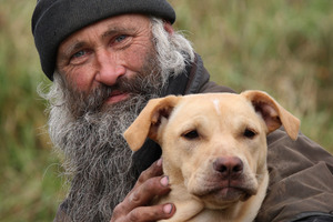 Rowan Hargreaves with one of his dogs, Chicken, the only surviving puppy of a dog massacre. Photo / Natalie Slade