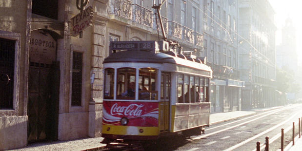 A tram makes its way along a Lisbon street at sunset. Photo / Mark Fryer