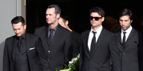 Pallbearers (including Karl Urban, front right) carry the casket from the church at the funeral. Photo / Doug Sherring