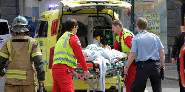 A man who set fire to himself outside the courthouse in Oslo Tuesday, May 15, 2012, where the trial of Anders Behring Breivik is taking place, is taken into an ambulance. Photo / AP
