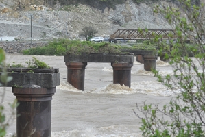 The Grey River rages around the old piles for the Cobden Bridge at Greymouth. Photo / Supplied
