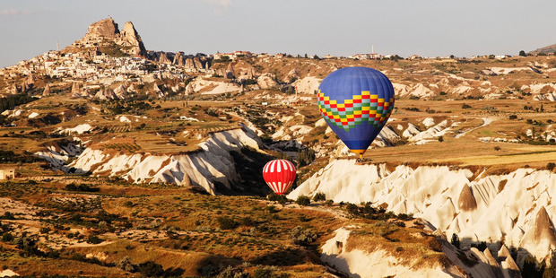 Blue and red hot air balloons float above Uchisar. Photo / Thinkstock
