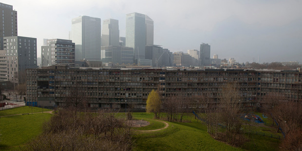 The towers of the Canary Wharf business and shopping district rise beyond the Robin Hood Gardens estate in London's borough of Tower Hamlets. Photo / Bloomberg