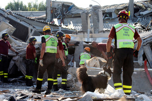 Rescue teams use dogs as they look for three workers reported missing at the Haemotronic factory in Medolla, northern Italy after the 5.8 quake which struck there. Photo / AP