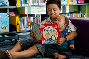 Terenui Natua, 8, reads to his little brother Arani, 1, at the Tupu Youth Library, Flat Bush. Photo / Brett Phibbs