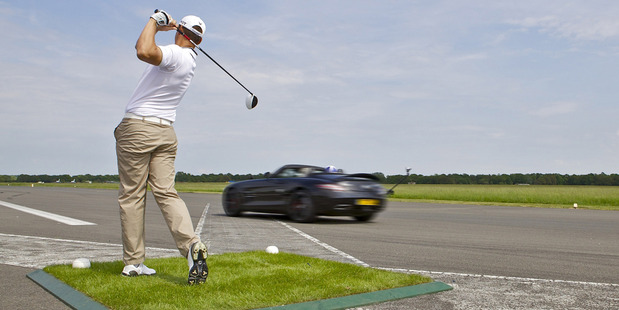Pro golfer Jake Shepherd hits a flying ball for race star David Coulthard to catch in a luxury Mercedes-Benz Roadster. Photo / Supplied