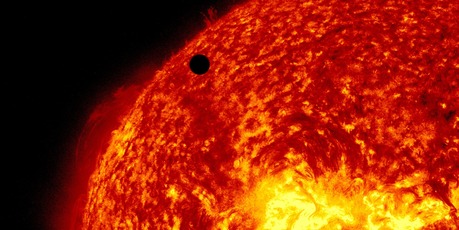 This image provided by NASA shows the Solar Dynamic Observatory's ultra-high definition view of Venus, black dot at top centre, passing in front of the sun.