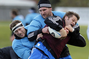 Richie McCaw is tackled by Wyatt Crockett and Kieran Read during an All Blacks training session. Photo / Getty Images