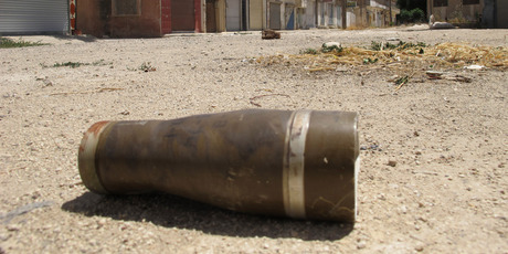 A shell is seen in a street at a residential area of Talbisah in Homs city Syria. Photo / AP