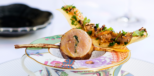 Quail and a wafer thin crisped potato strip spread with duck liver parfait balanced atop a floral tea cup. Photo / Babiche Martens