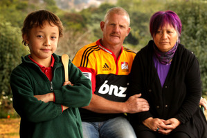 Brian (Centre) and Hannah Johnson pictured with their grandson, Shayne Ahomiro,8,(Left) at home in Tauranga today. Shayne is pictured holding the wooden spoon.