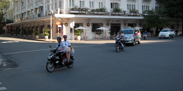 Motorcyclists pass in front of the Continental Hotel in Ho Chi Minh City, Vietnam. The city's colonial-era hotels are a colourful but comfortably up-scale alternative to global accommodation chains. Photo / Suree Pritchard