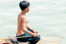 A Vietnamese boy fishes for turtles on the Saigon River, just metres from the streets of Ho Chi Minh City. Photo / Bay of Plenty Times A Vietnamese boy fishes for turtles on the Saigon River, just metres from the streets of Ho Chi Minh City. Photo / Bay of Plenty Times