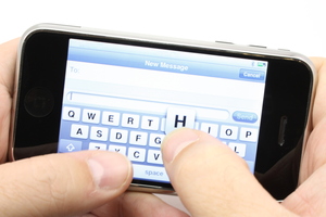 Texting on a touch screen phone turned sideways.