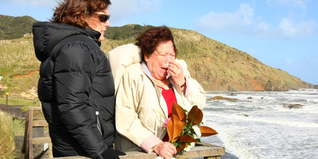 Judith Furlong and a police family liaison officer at Sunset Beach, Port Waikato, where Jane's remains were found. Photo / Chris Gorman
