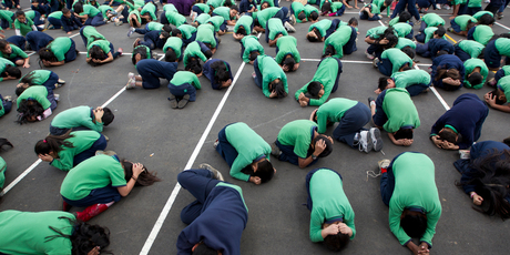 Children from Mt Roskill and Mt Eden Primary Schools practise the 'drop, cover and hold' technique. Photo / Steven McNicholl