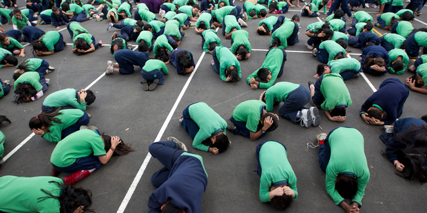 Children from Mt Roskill and Mt Eden Primary Schools practise the 'drop, cover and hold' technique. Photo / Steven McNicholl