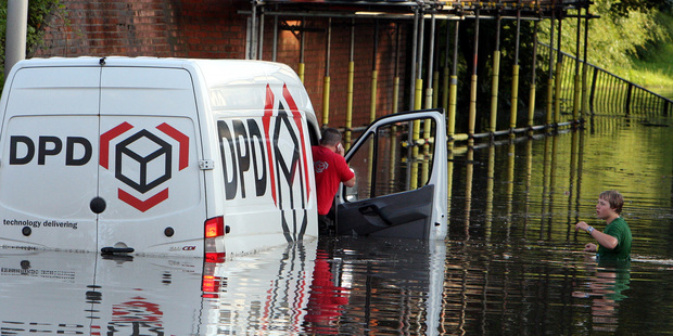 A man helps a stranded van driver in Jarrow, England, Photo / AP