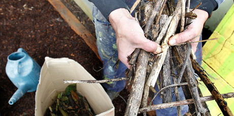 Justin Newcombe prepares sticks and other organic material in a box for composting. Photo / Steven McNicholl
