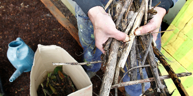 Justin Newcombe prepares sticks and other organic material in a box for composting. Photo / Steven McNicholl