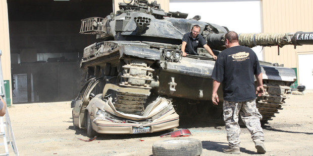 At a Minnesota 'theme park' frustrated motorists are climbing into surplus Cold War army tanks to crush junk cars - and loving it.