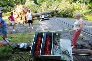 Marilyn Golias, right, looks at the remains of a utility pole which fell across the street from her house in Falls Church, Virginia. Photo / AP