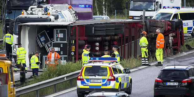 Police work to clear the motorway after one of Madonna's tour trucks crashed in Sweden. Photo / AP