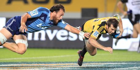 Chris Lowrey fails to stop Conrad Smith as he scores the winning try for the Hurricanes against the Blues. Photo / Greg Bowker.